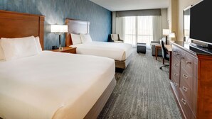 A hotel room with two beds, a desk, a TV, and a large window. - Drury Plaza Hotel Denver Westminster (Westminster)