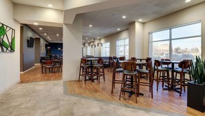 A spacious indoor area with multiple tables and chairs, large windows, and a modern ceiling design. - Drury Plaza Hotel Denver Westminster (Westminster)