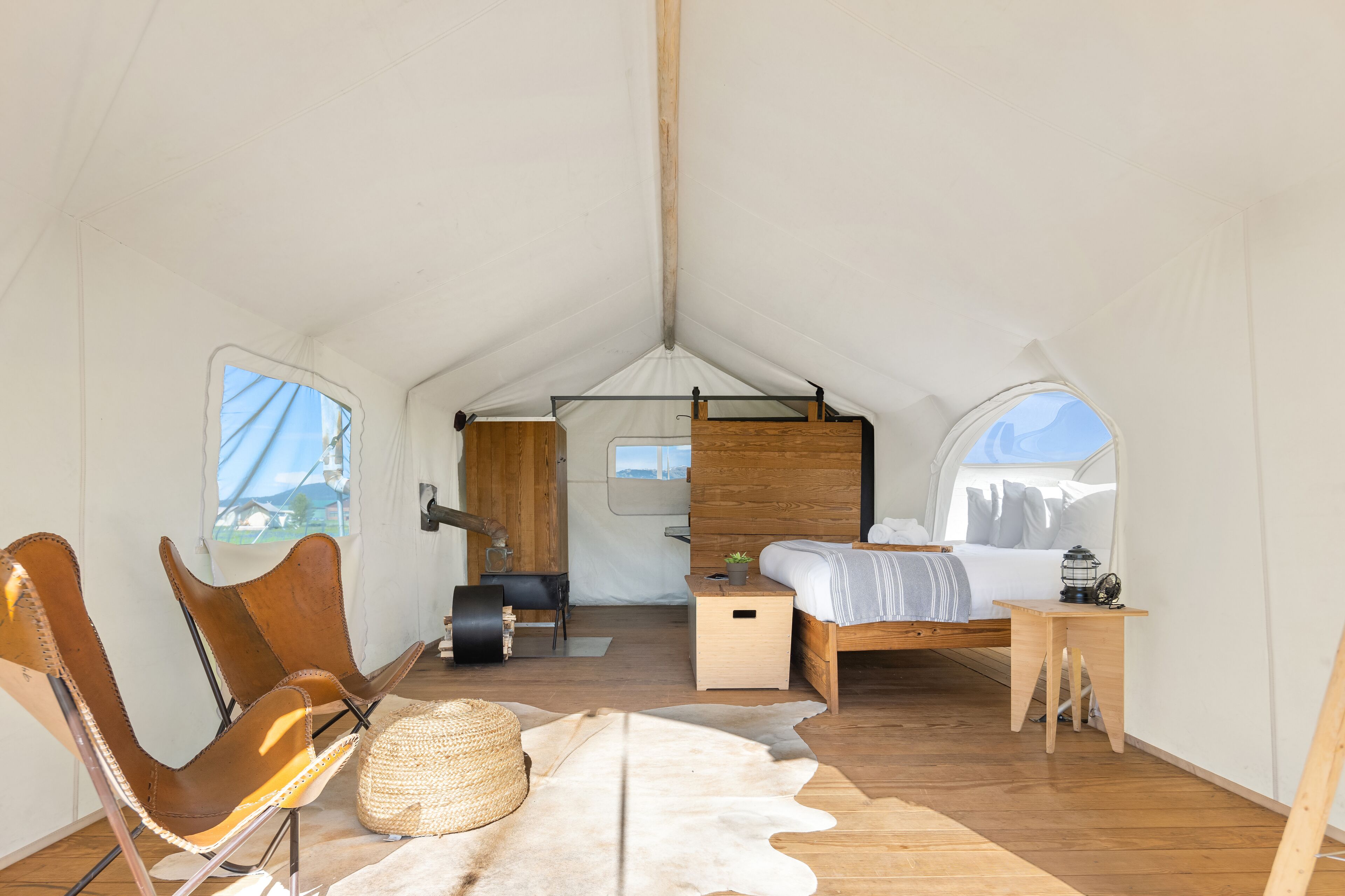 Een tentaccomodatie met een bed, zithoek en een tafeltje.