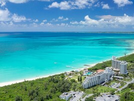 A resort with a pool, beachfront, and a large building.