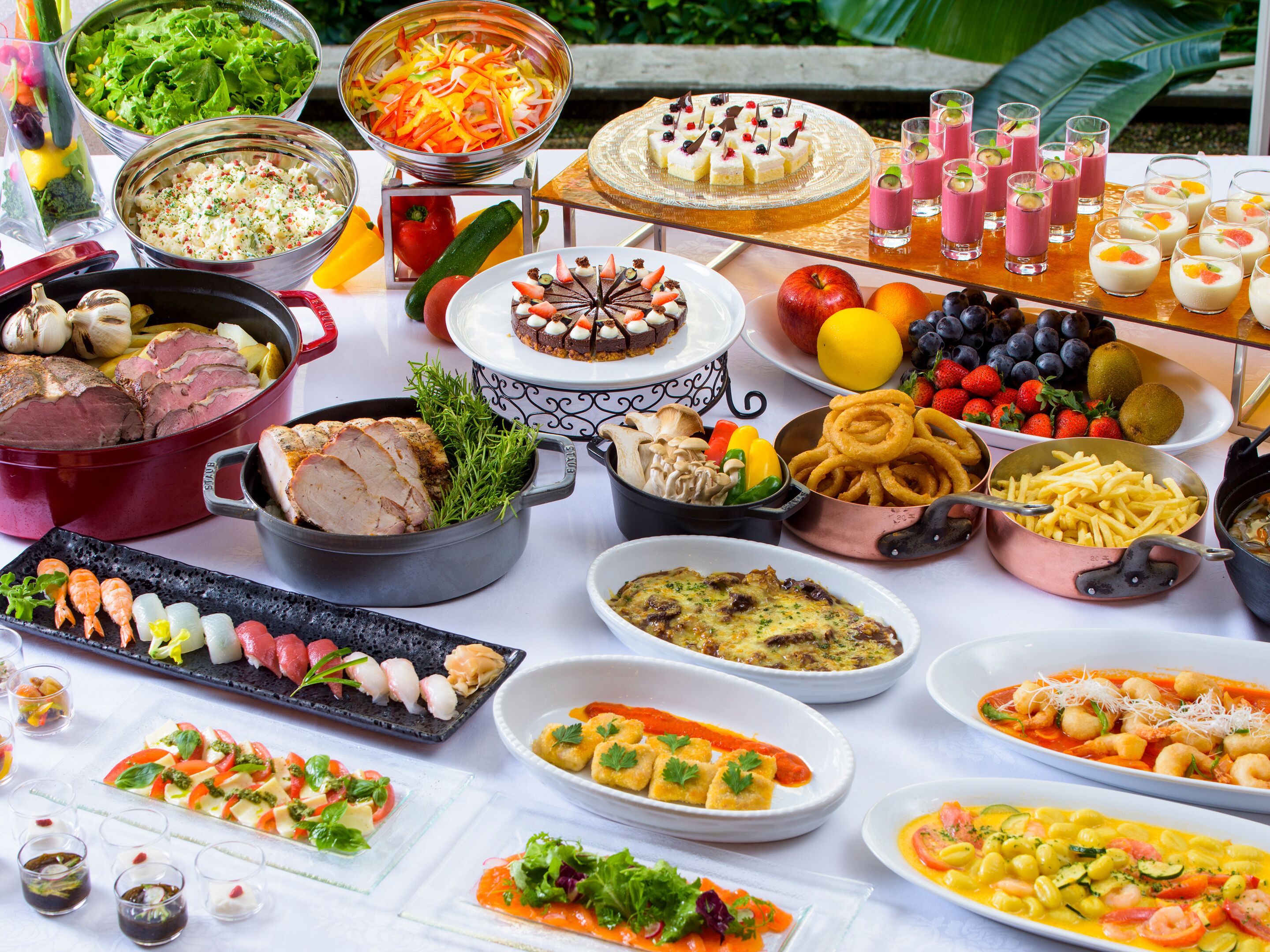Un bufé con una variedad de platos, incluyendo carnes, ensaladas y postres.