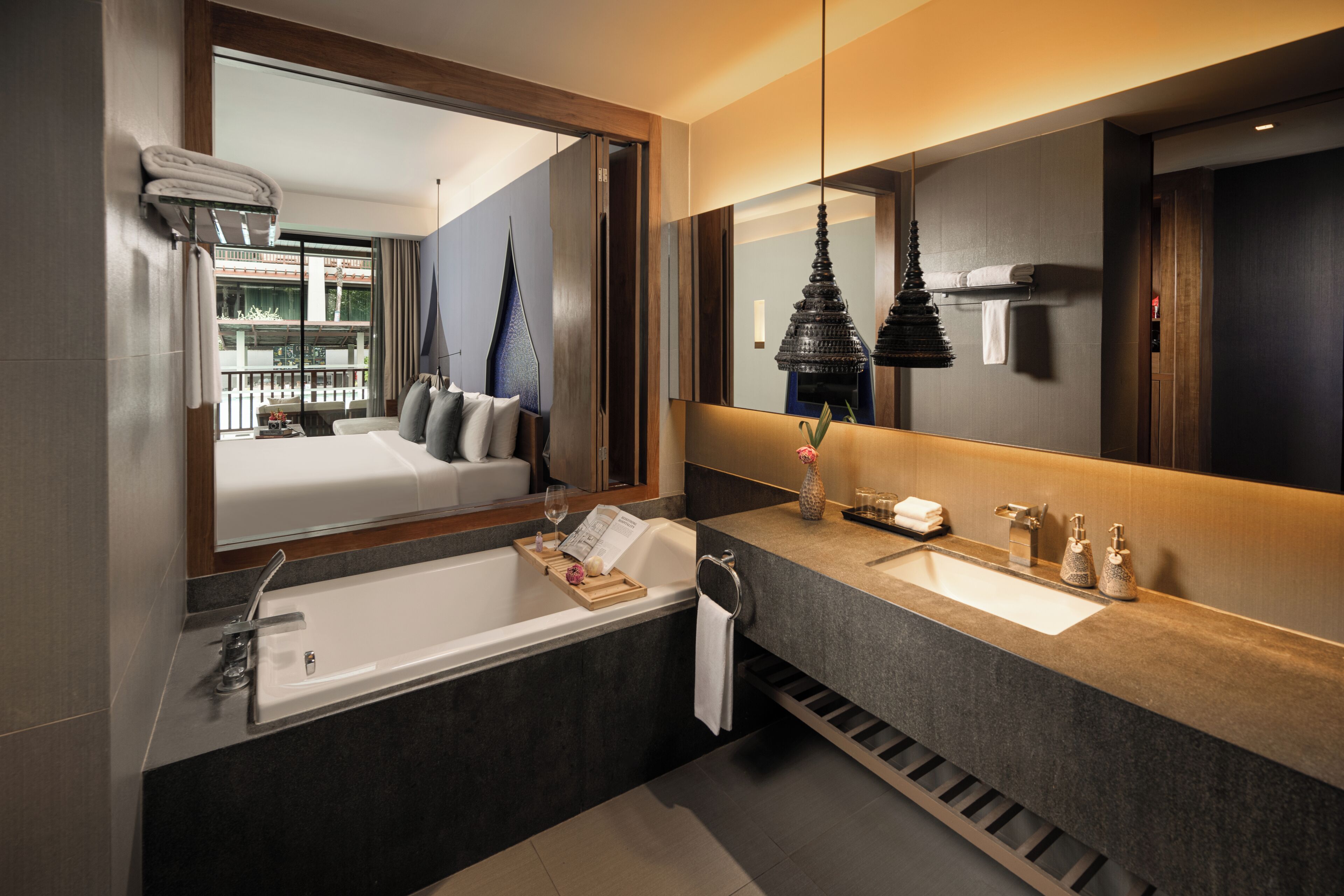 Ein modernes Badezimmer mit großem Spiegel, einer Badewanne und einem Waschtisch.