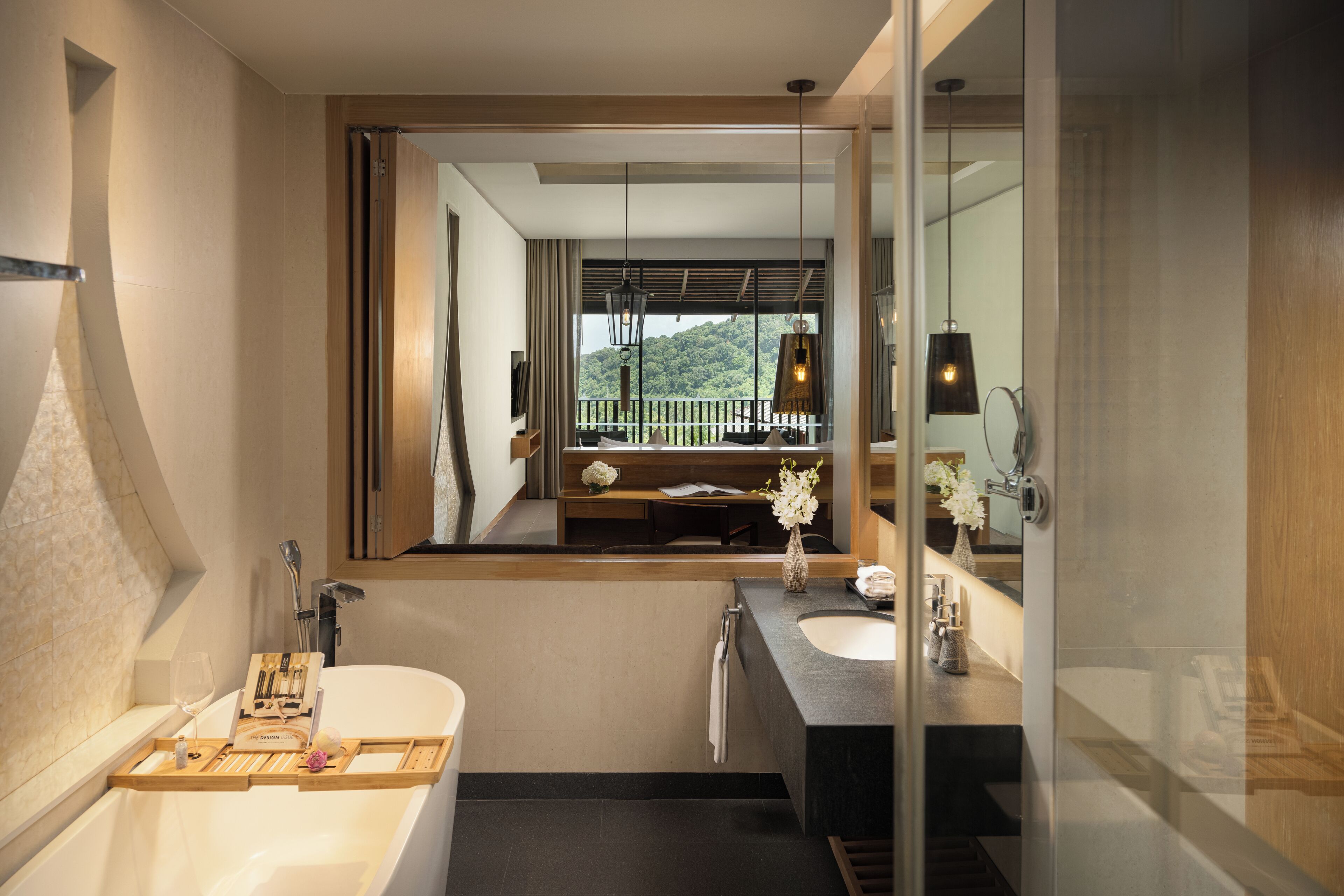 A modern bathroom with a bathtub, two sinks, a vanity, and a large mirror.