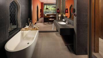 Un baño moderno con una bañera independiente, un tocador con espejo y una ventana con vistas al exterior.