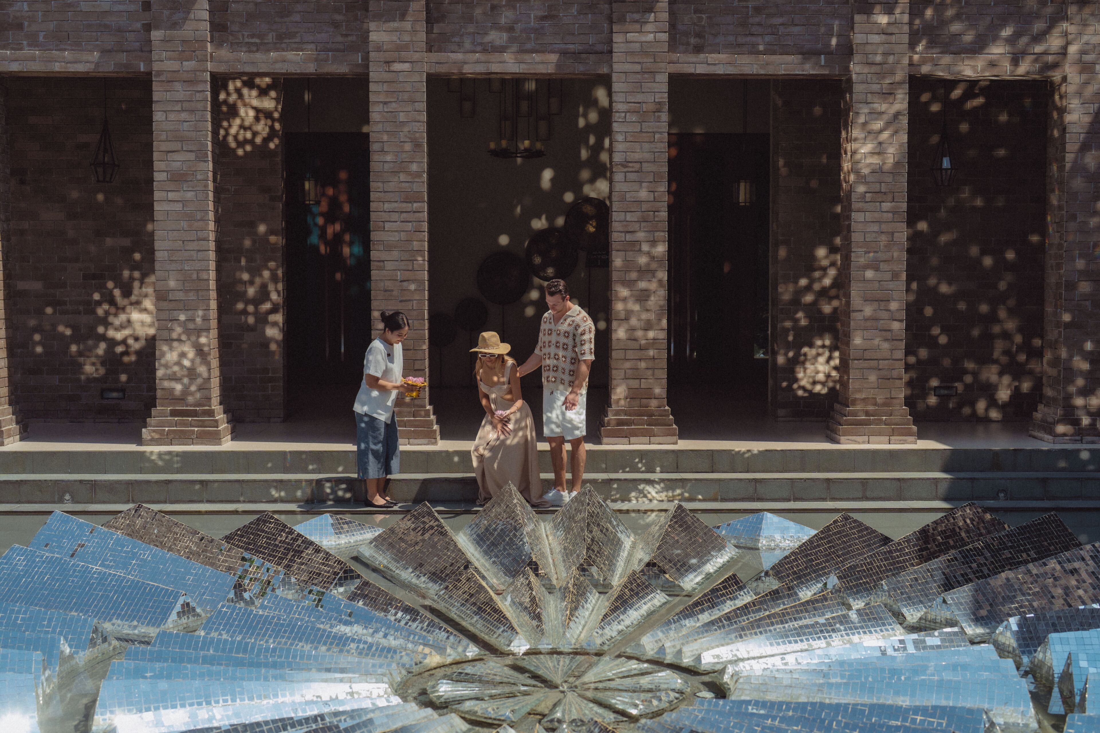 A building with a brick facade, large windows, and a central decorative element resembling a fan or flower.