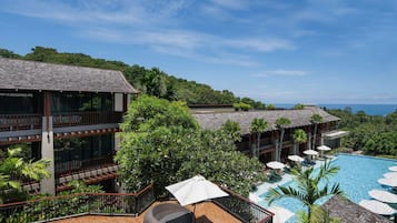 Ein Resort mit Pool, Sitzgelegenheiten im Freien und Blick auf den Ozean.