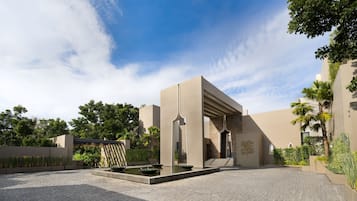 A courtyard with a modern building, a water feature, and surrounding greenery.