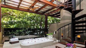 A modern spa area with a large bathtub, wooden seating, and a glass enclosure with greenery. - Avista Hideaway Phuket Patong - MGallery (Patong)