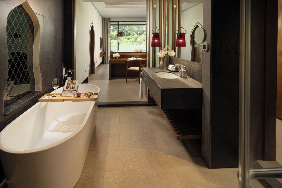 Un baño moderno con una bañera independiente, un tocador con espejo y una zona de ducha.