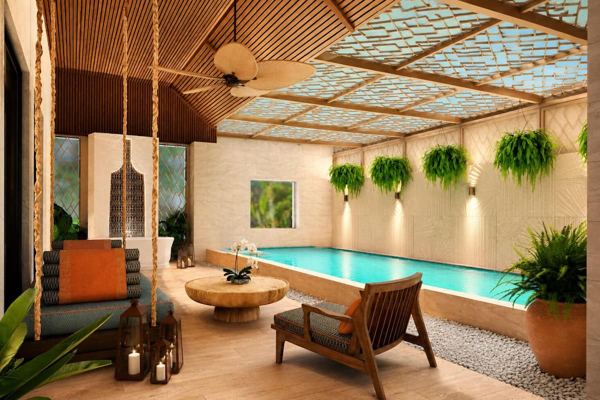 A modern indoor pool area with a wooden ceiling, seating, and potted plants.