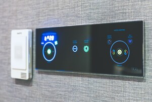 Un panel de control digital con un reloj, opciones de iluminación ambiental y un interruptor de encendido.
