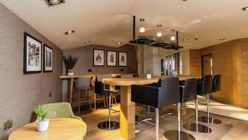 A modern dining area with a wooden table, black chairs, and a potted plant.