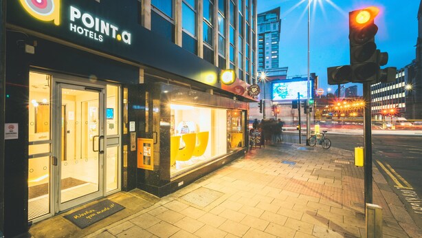 A hotel entrance with glass doors, a 'No Smoking' sign, and a 'Welcome' mat outside. - Point A London Waterloo (London)
