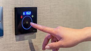 A hand interacting with a control panel displaying a temperature setting of 16.0°C. - Point A London Waterloo (London)