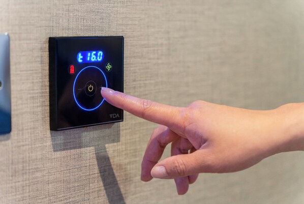 A hand interacting with a control panel displaying a temperature setting of 16.0°C. - Point A London Waterloo (London)