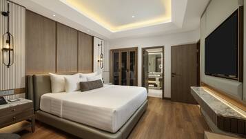 A modern hotel room with a large bed, a TV, and a walk-in closet.