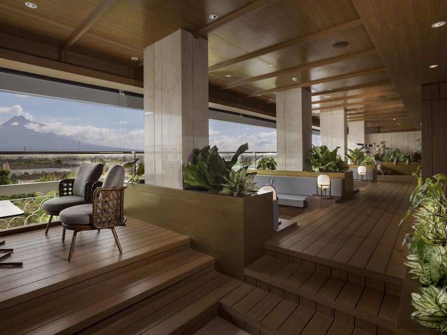 A modern outdoor lounge area with wooden flooring, seating, and potted plants.