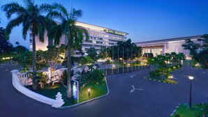A hotel with a modern design, featuring a large building with multiple floors and a well-lit entrance.