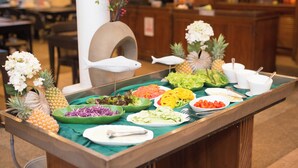 A buffet table with various food items and decorative elements. - The Viridian Resort (Patong)