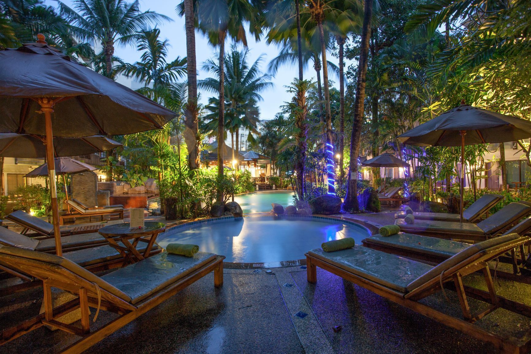 Una piscina al aire libre, camas de piscina gratis, sombrillas