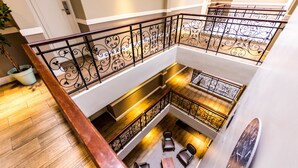 A multi-level interior with a wooden floor, metal railings, and seating areas. - The New Tulbagh Hotel (Cape Town)