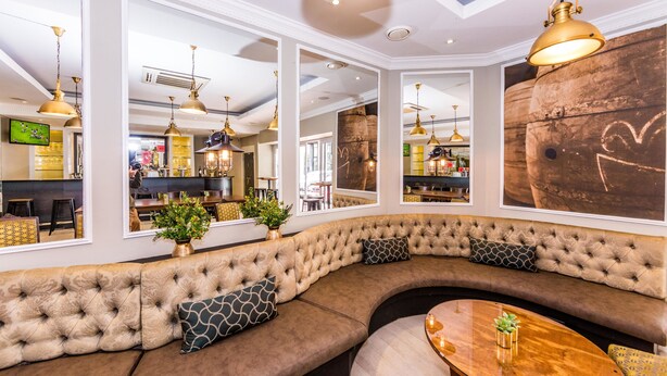 A modern interior with a curved sofa, large mirrors, and pendant lighting. - The New Tulbagh Hotel (Cape Town)
