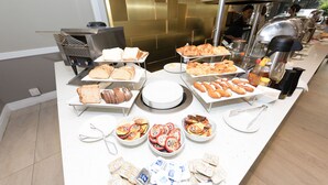 A buffet with various food items including bread, pastries, and hot dogs. - The New Tulbagh Hotel (Cape Town)