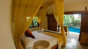 Un dormitorio con cama, cortinas, una lámpara y vista a una piscina.