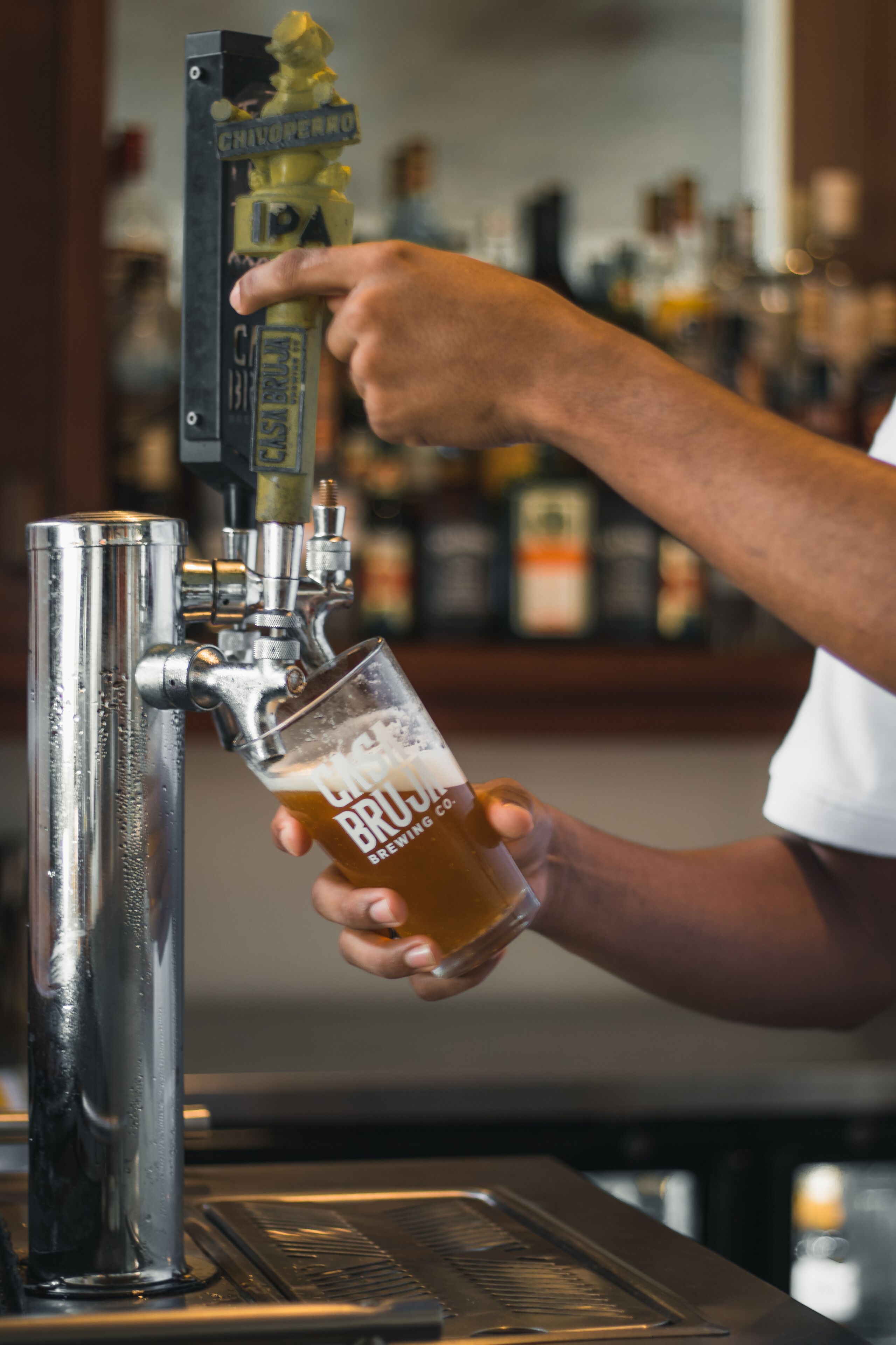 Eine Hand zapft Bier in ein Glas.