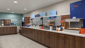 A modern breakfast area with a counter displaying various food items and a sign that reads "THIS IS HOW WE ROLL". - Holiday Inn Express Hotel & Suites NORTH FREMONT by IHG (Fremont)