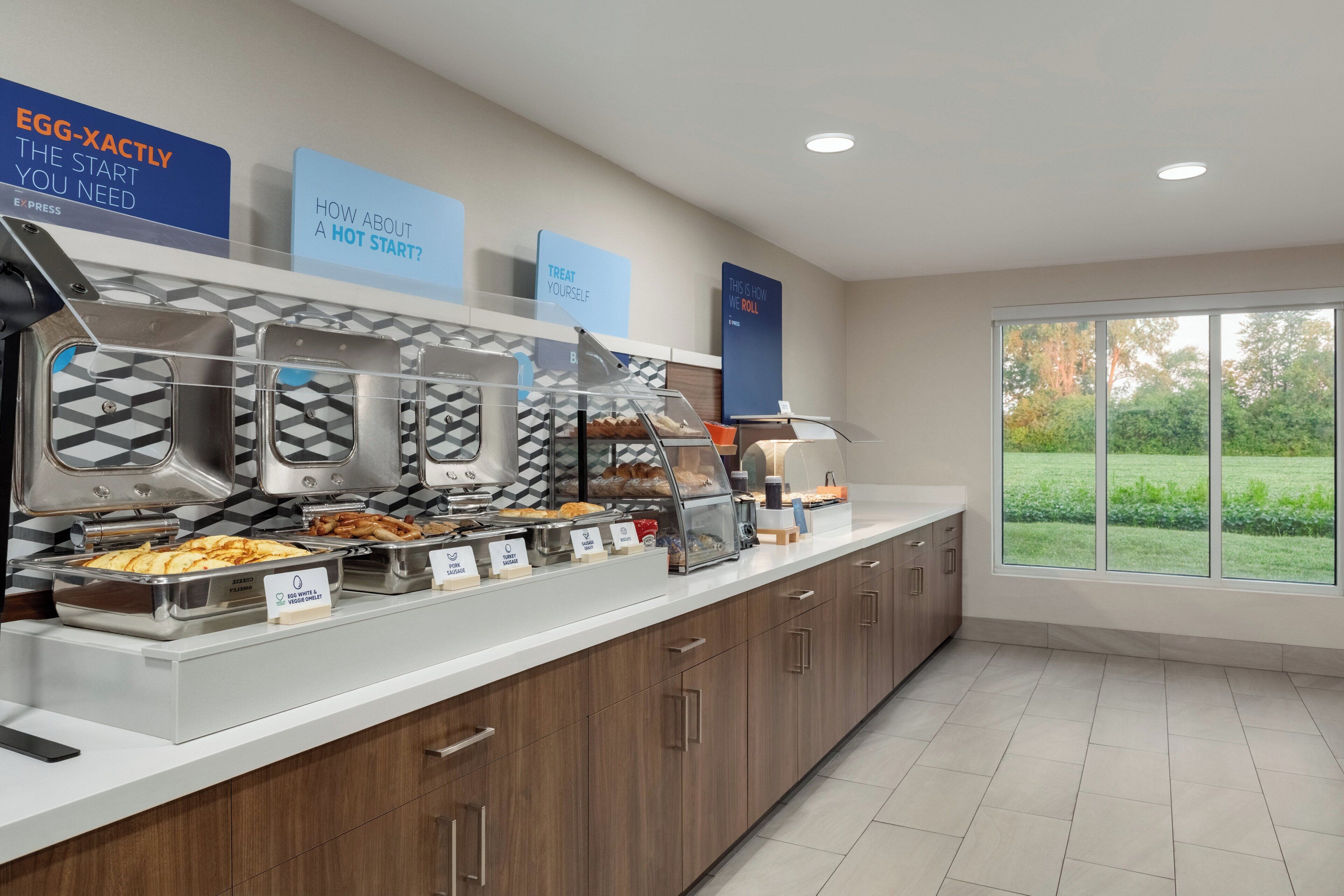 Un buffet de petit-déjeuner proposant une variété de plats et agrémenté de panneaux explicatifs.