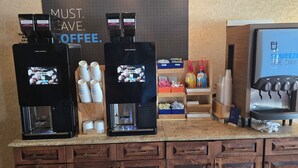 Un espace dédié au café, équipé de deux machines à expresso, d’un distributeur d’eau et d’un moulin à café.
