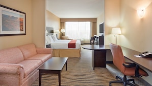 A hotel room with a bed, a sofa, a desk, and a TV. - Holiday Inn Express Hotel & Suites Gallup East by IHG (Gallup)