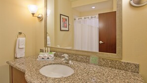 A bathroom with a granite countertop, a sink, a mirror, a towel rack, and a shower curtain. - Holiday Inn Express Hotel & Suites Gallup East by IHG (Gallup)