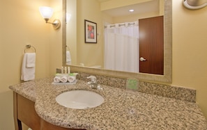 A bathroom with a granite countertop, a sink, a mirror, a towel rack, and a shower curtain. - Holiday Inn Express Hotel & Suites Gallup East by IHG (Gallup)