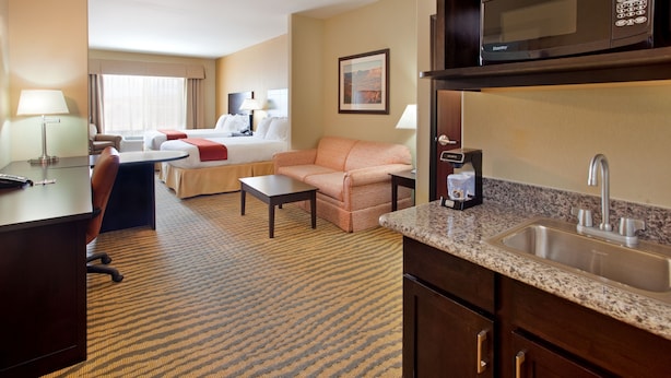 A hotel room with a bed, a sofa, a desk, a coffee maker, a microwave, and a sink. - Holiday Inn Express Hotel & Suites Gallup East by IHG (Gallup)