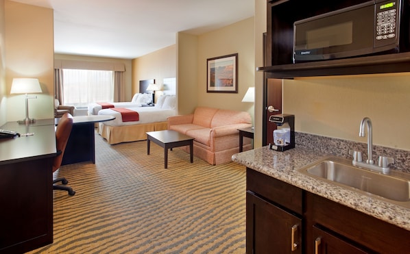 A hotel room with a bed, a sofa, a desk, a coffee maker, a microwave, and a sink. - Holiday Inn Express Hotel & Suites Gallup East by IHG (Gallup)