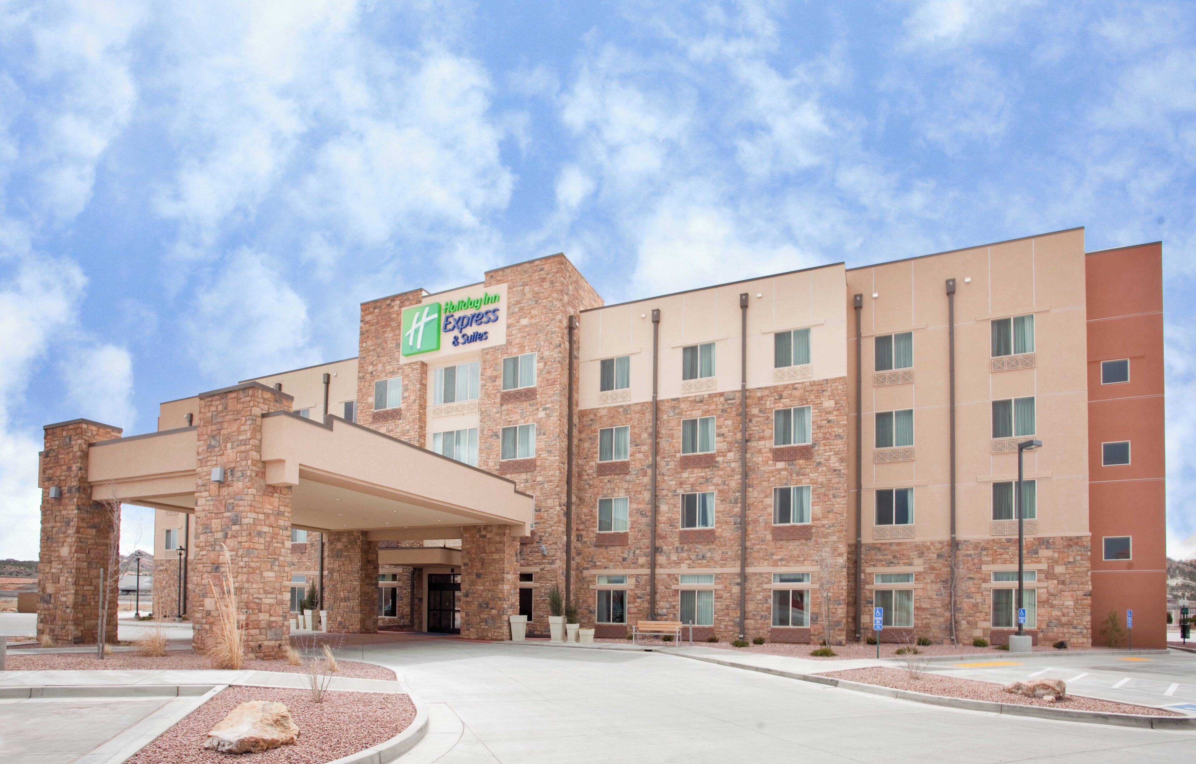Um hotel Holiday Inn Express & Suites com fachada de tijolos, várias janelas e entrada coberta.