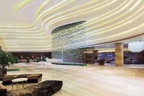 A spacious lobby with a modern design, featuring a central decorative light installation and seating areas. - Holiday Inn Chengdu Xindu by IHG (Chengdu)