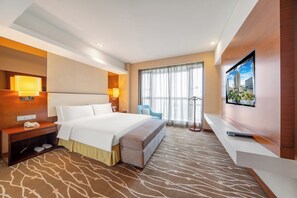 A hotel room with a bed, bedside table, lamp, TV, and a view of the city. - Holiday Inn Chengdu Xindu by IHG (Chengdu)
