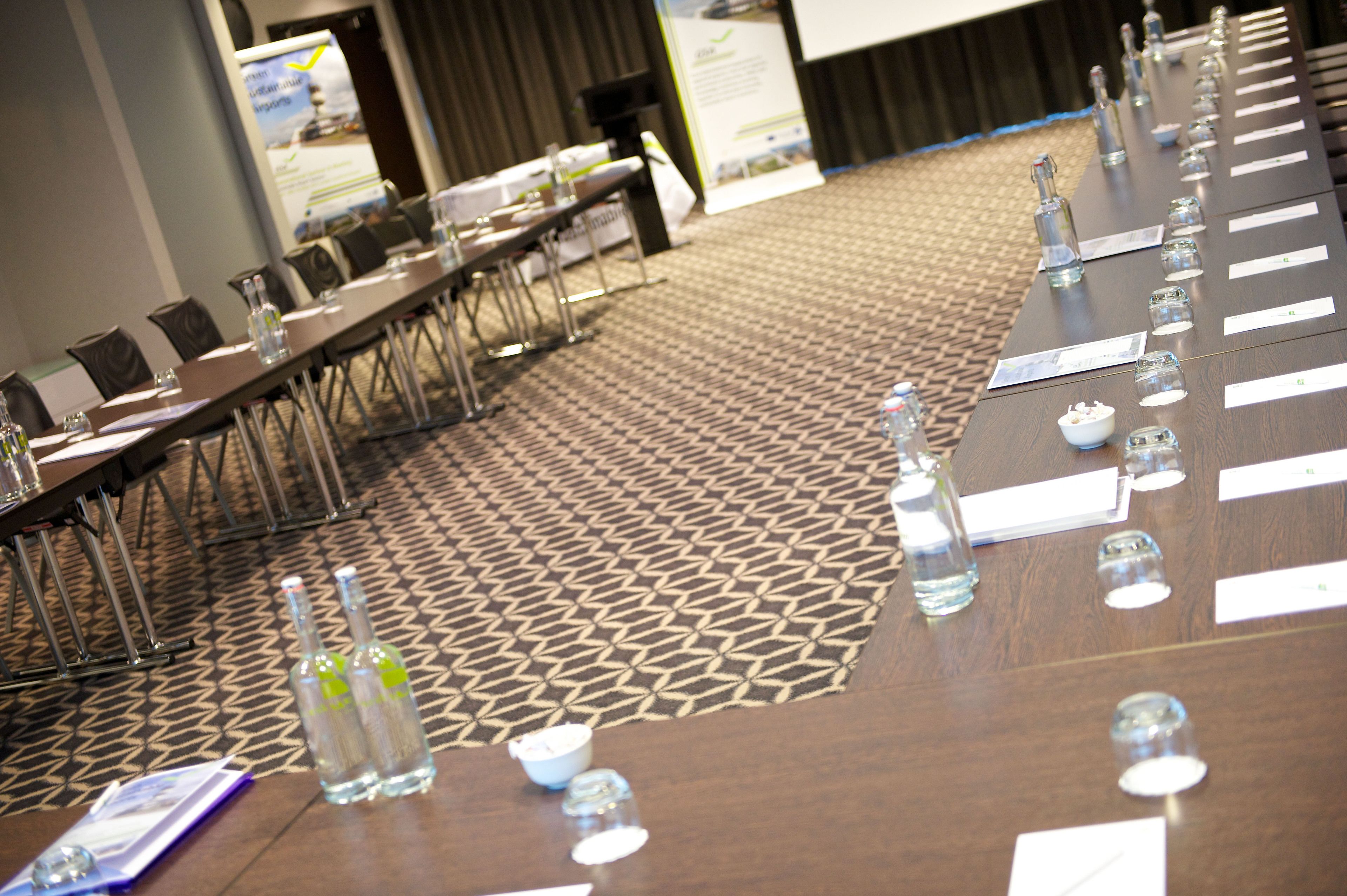 A conference room with a long table, chairs, water bottles, and name cards.