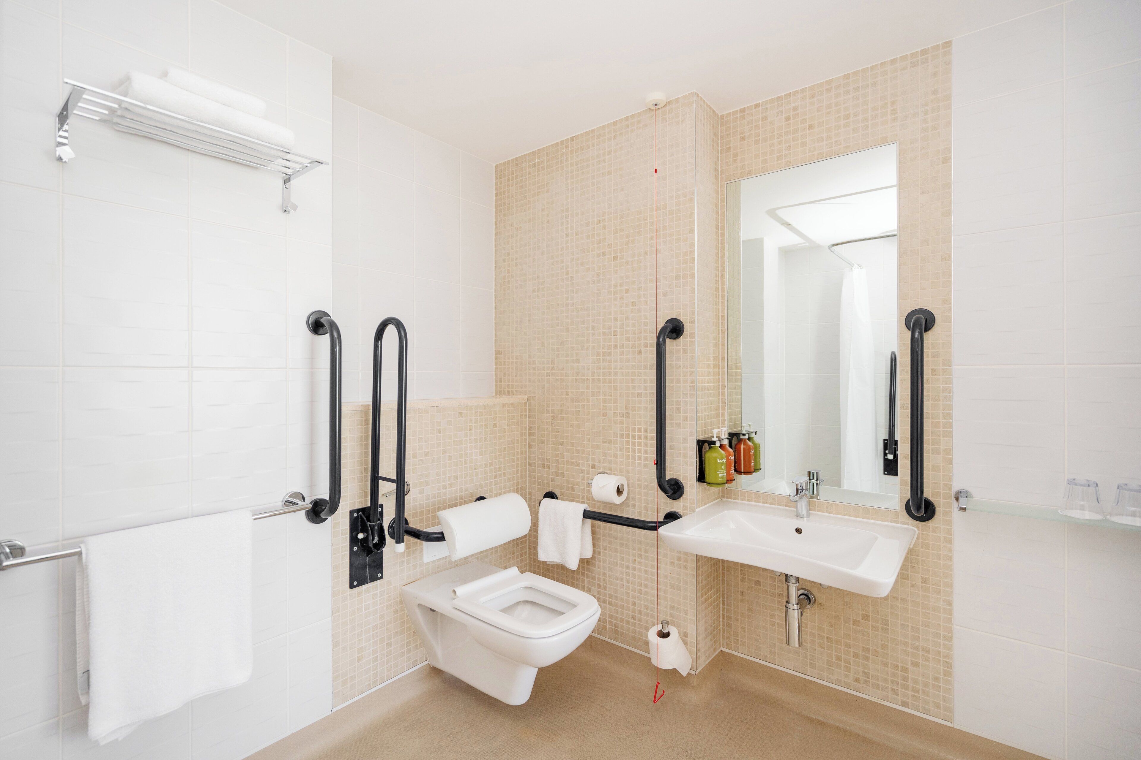 Un baño moderno con inodoro, lavamanos y espejo.
