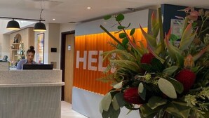 A reception area with a modern design, including a reception desk, a large plant arrangement, and a wall with the word "HEC" prominently displayed. - Holiday Inn Express Windsor by IHG (Windsor)