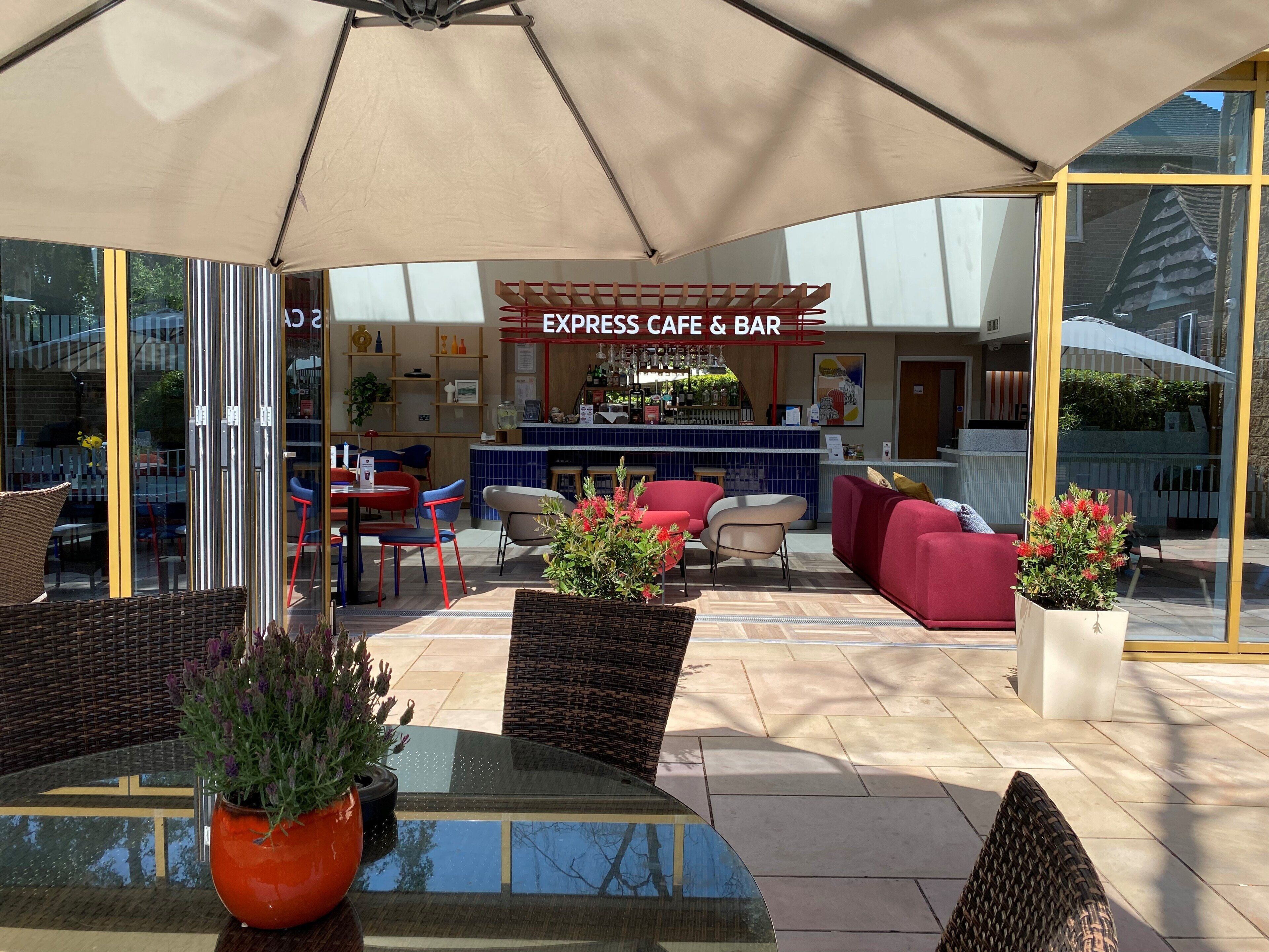 An outdoor seating area with tables, chairs, and a bar.