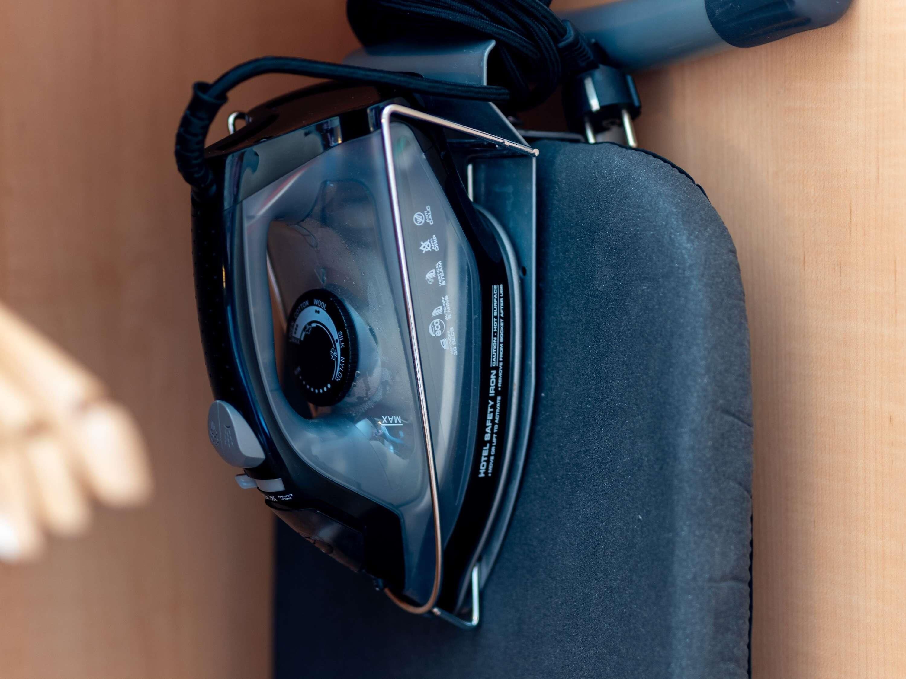 Un dispositivo electrónico negro con un dial y una etiqueta que dice 'MOTEL SAFETY IRON'.