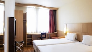 A hotel room with two beds, a desk, a chair, and a TV. - ibis Krakow Stare Miasto (Kraków)