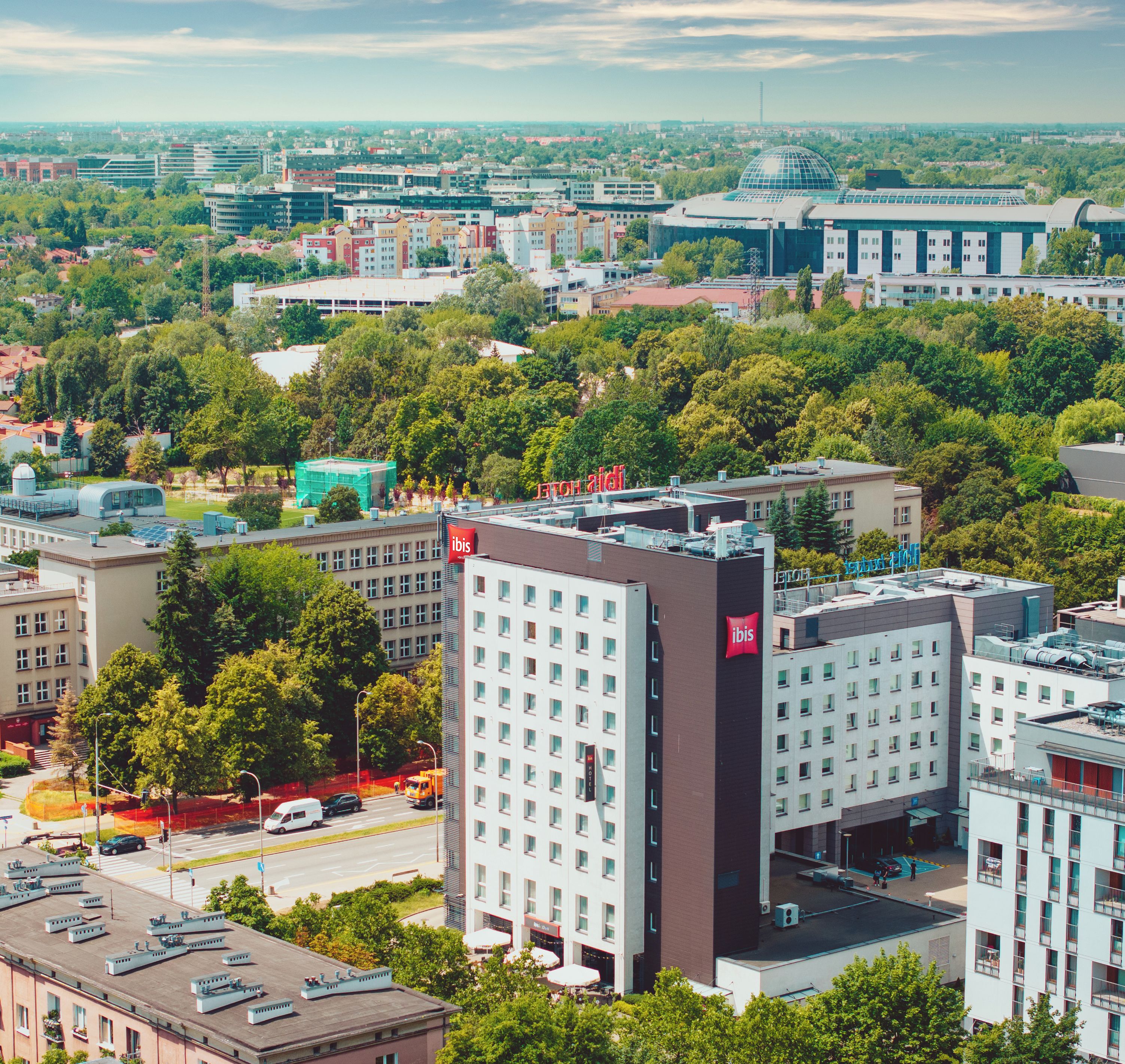 Ett högt hotell med många våningar, en framträdande röd flagga på hörnet och utsikt över den omgivande stadsbilden.