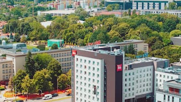 Ett högt hotell med många våningar, en framträdande röd flagga på hörnet och utsikt över den omgivande stadsbilden.