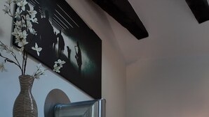 A modern interior with a built-in fireplace, a black and white artwork, and a vase with flowers. - The More Hotel Lund (Lund)