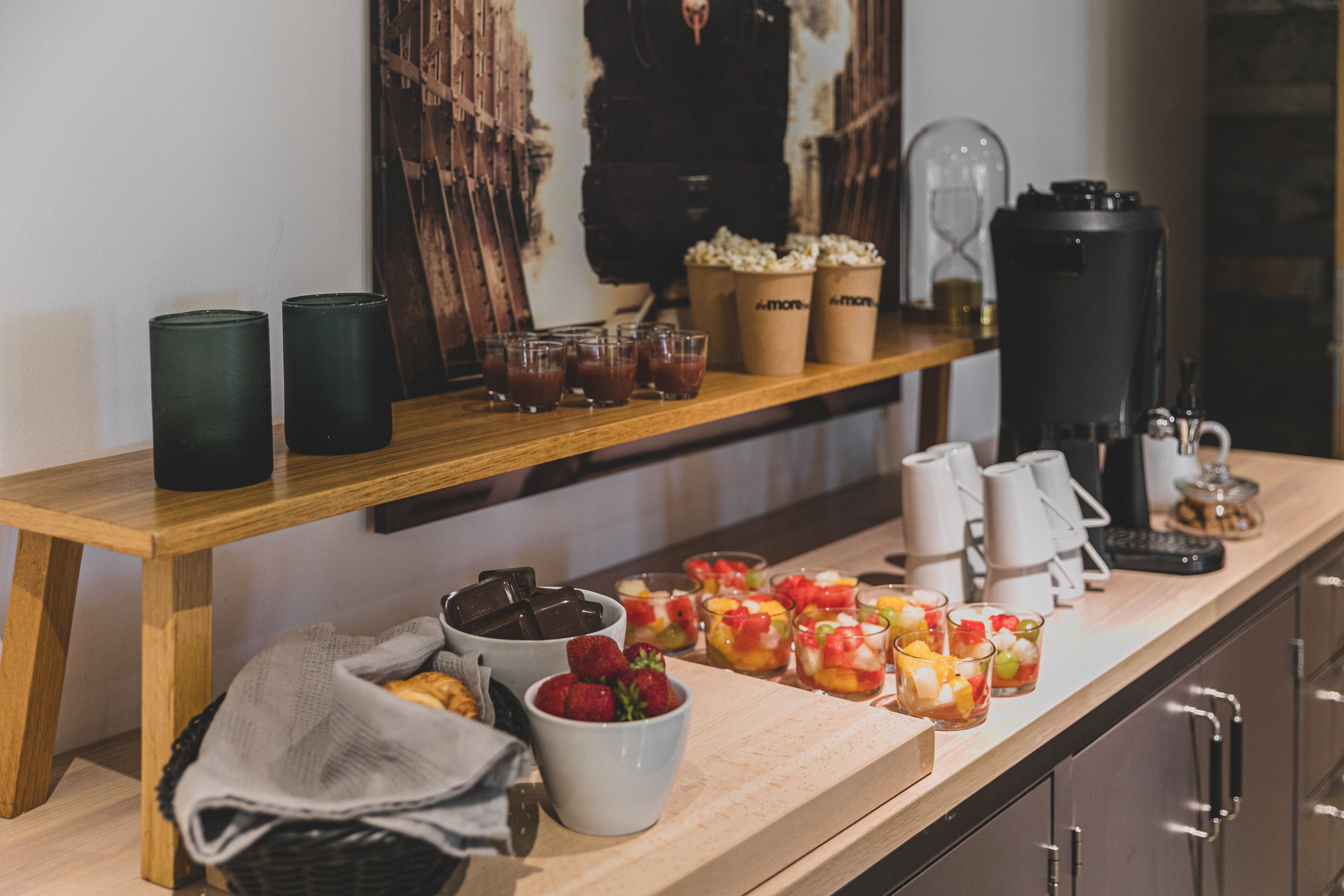 A breakfast bar with various beverages, snacks, and a coffee machine.